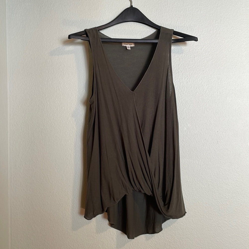 Dark olive green v-neck relaxed tank with twisted front hem detail.